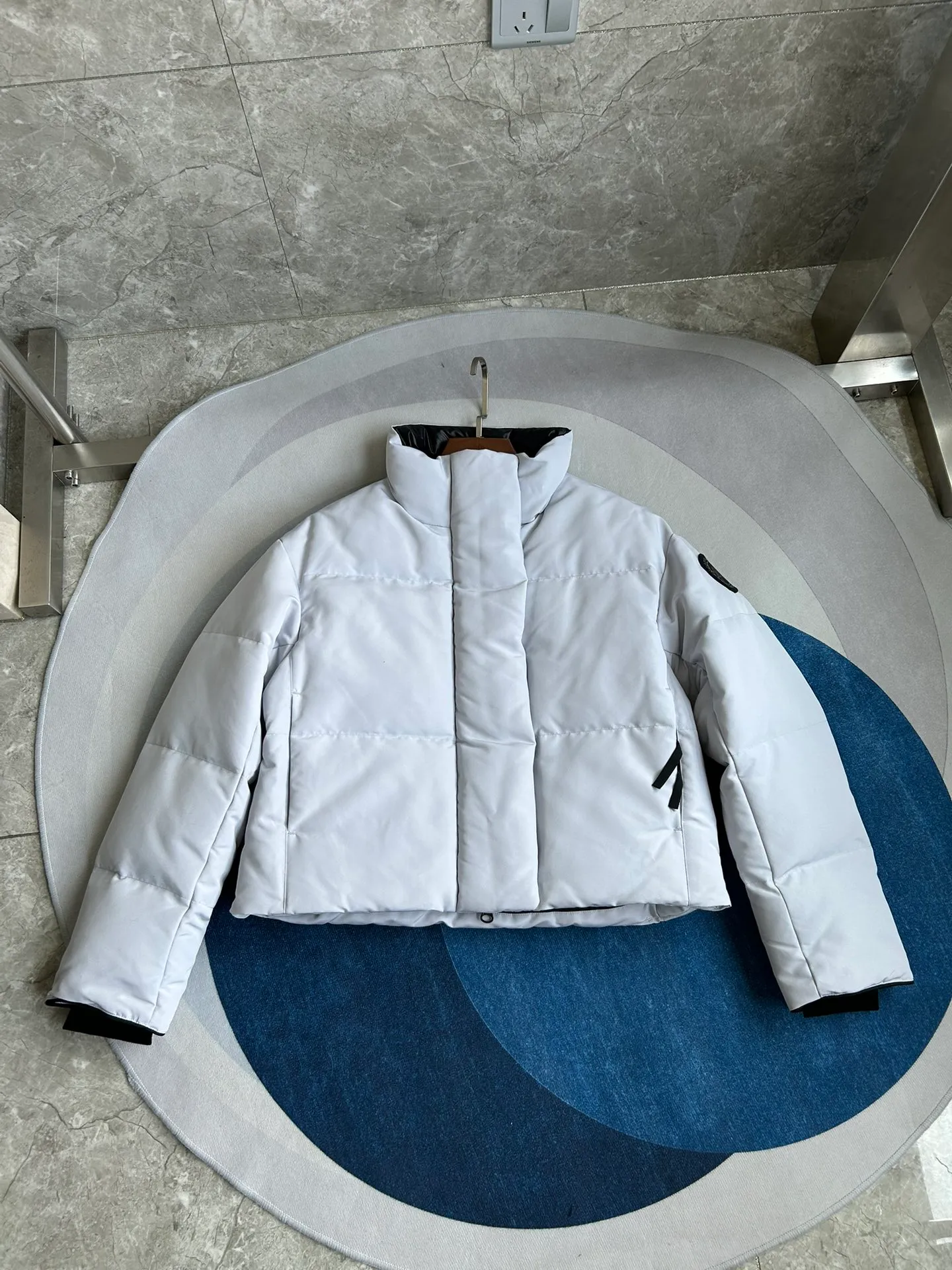 P880 E2266WB Grandview black label short jacket down jacket. Constructed from Arctic Tech recycled fabric®, it features a cinchable hem for sleek styling and storage. Color: White Star White. Size: XS S M L XL.
